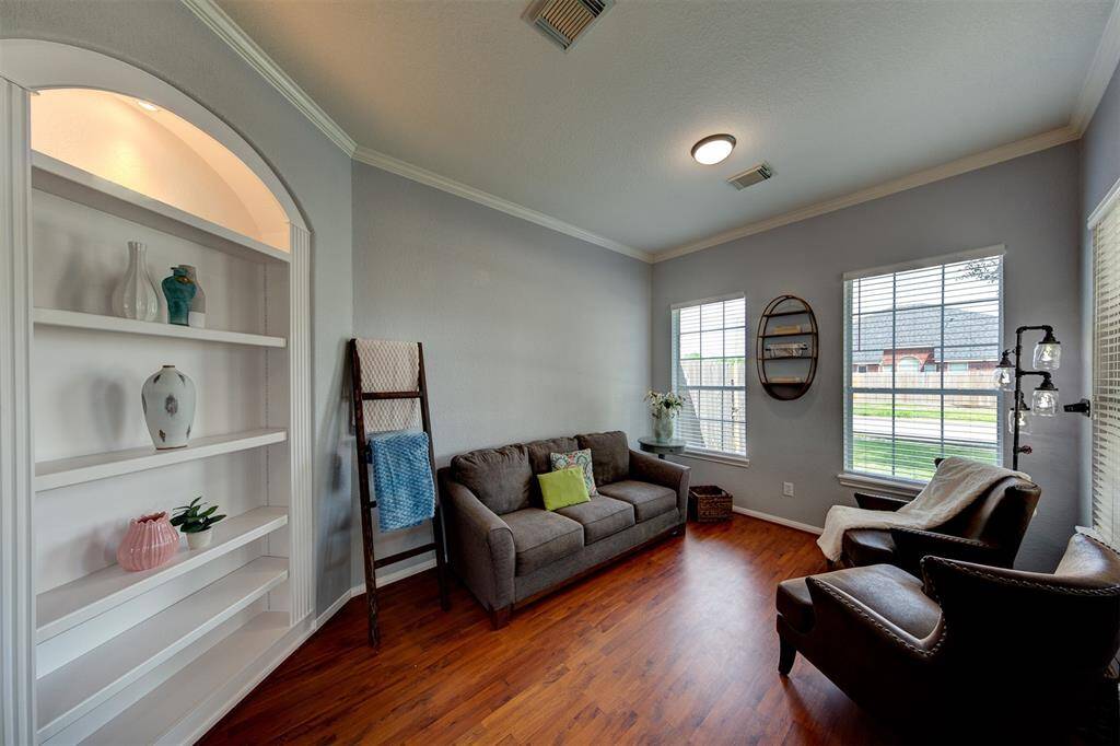 Den with built in shelves and 3 bright windows.