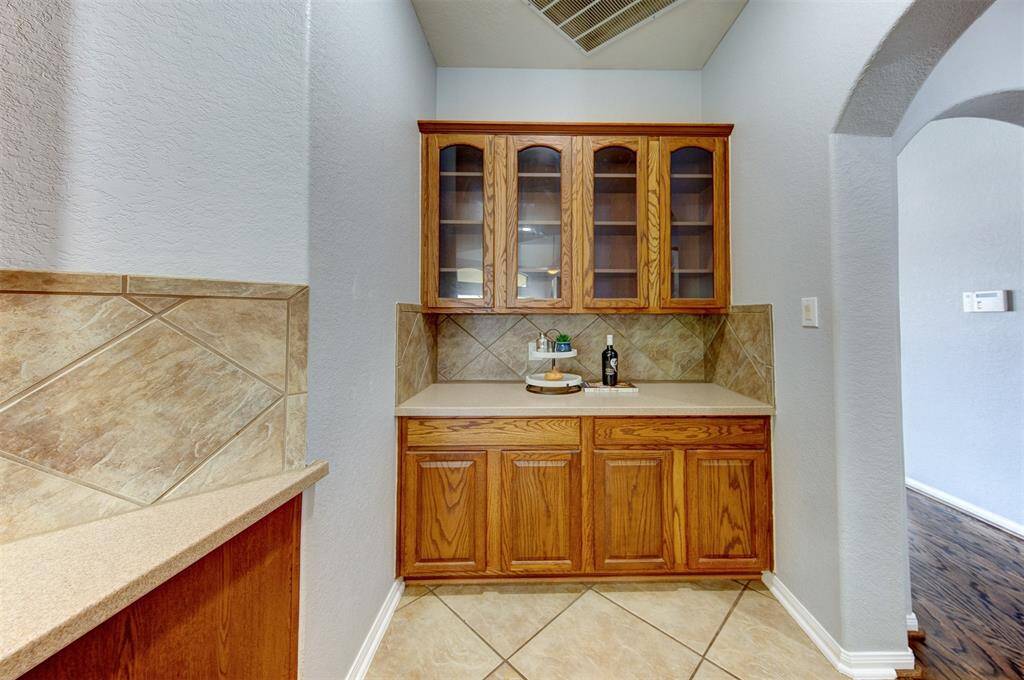Elegant butler's pantry with gleaming glass front cabinets and extra storage.