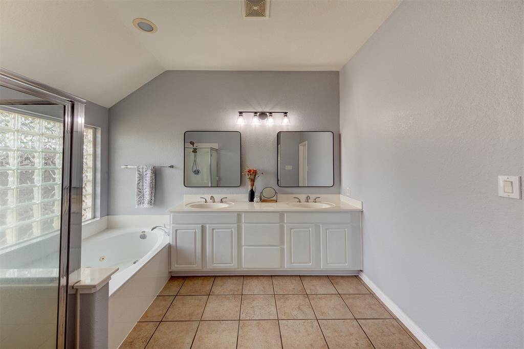 Trendy primary bath with double sinks and separate shower.