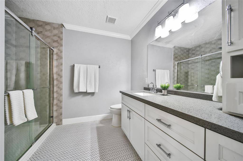 Spacious primary bathroom with glass shower.
