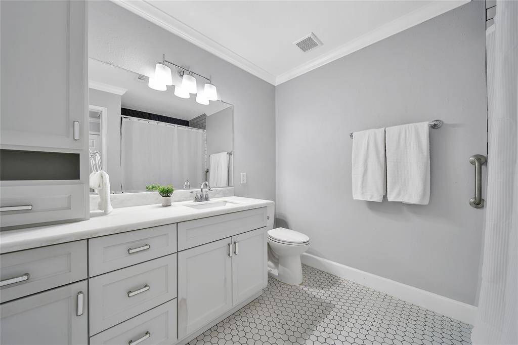 Secondary bathroom with ample storage and tub shower combo.