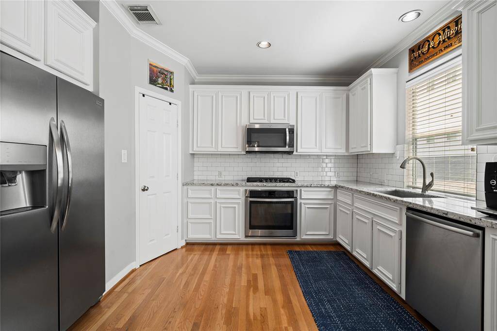 This elegant Perry Homes townhome boasts stainless steel appliances, sleek soft-close drawers and cabinets. With a spacious pantry, gas cooktop, and beautiful granite countertops, the stylish backsplash adds the perfect designer touch