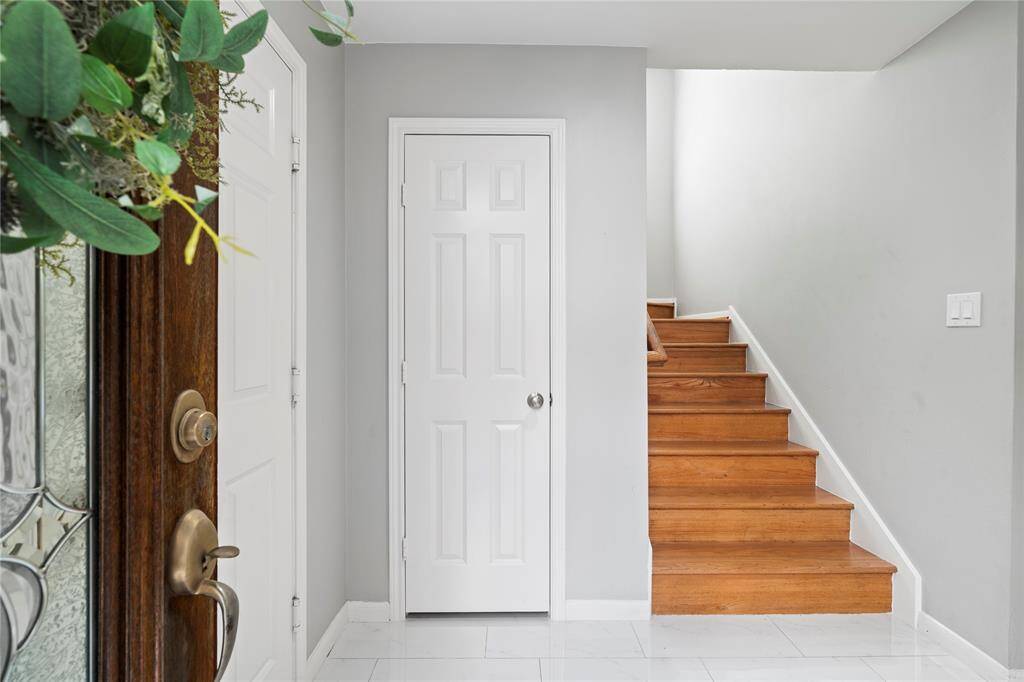 The entry features garage access, a coat closet, a downstairs bathroom, laundry room, and a versatile room perfect for a bedroom or an office. The front foyer flooring has been updated