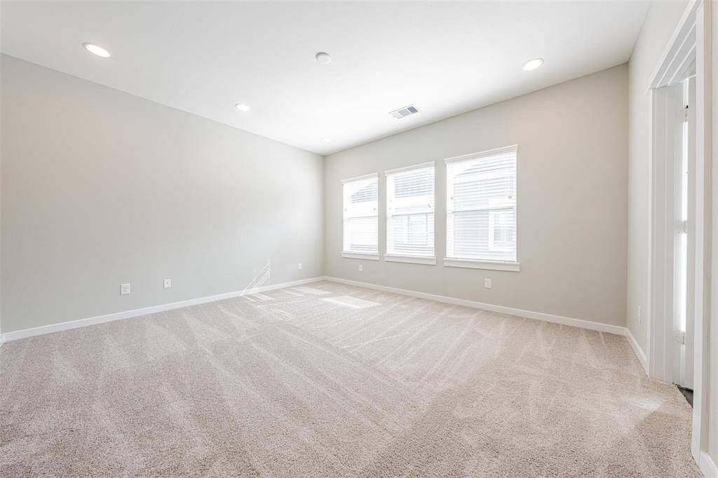 Large primary bedroom with lots of natural lighting.