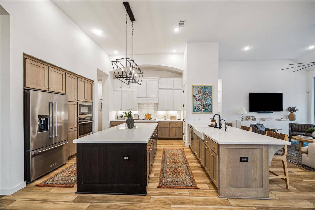 Yes...the kitchen is THATmagnificent! This space featuresa massive Island, warm naturalwood stained cabinets, quartzcountertops, and a practicalbreakfast bar!