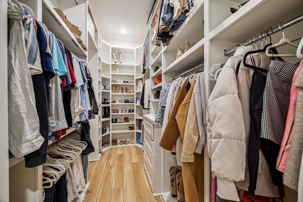 Custom Storage and shelving in the primary closet offers so much space for all your clothes!