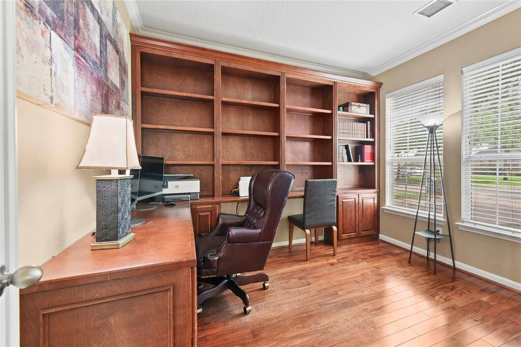 Elegantly crafted, the kitchen showcases stainless steel appliances, crisp white cabinetry, a stylish tile backsplash, and a spacious pantry.