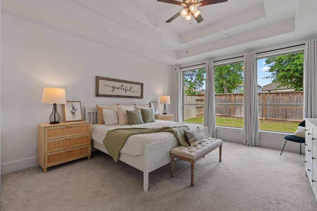 Experience tranquility in this spacious bedroom, featuring large windows with garden views and a cozy sitting area, flooded with natural light.