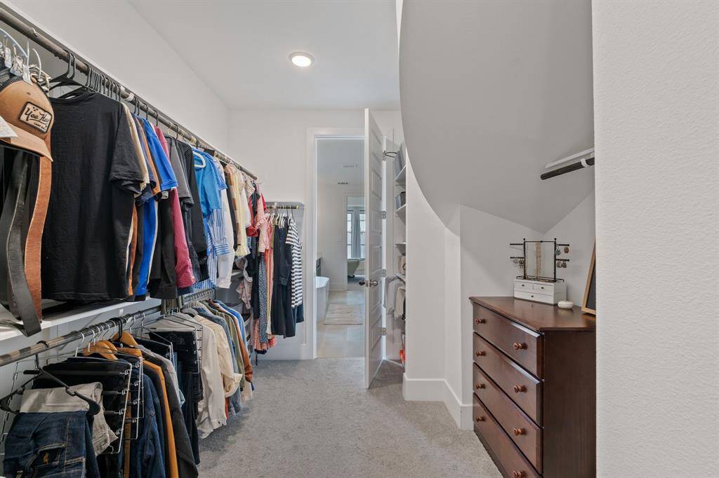 Spacious walk-in closet with abundant hanging space, seamlessly connecting to the primary bathroom for ultimate convenience.