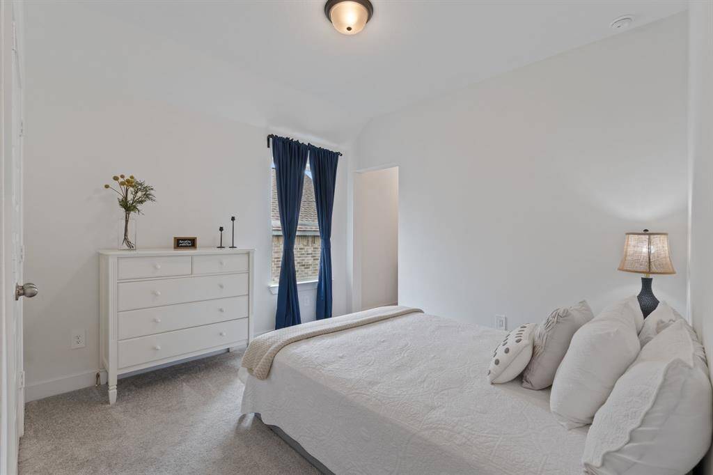 Upstairs secondary bedroom with abundant natural light and cozy ambiance.