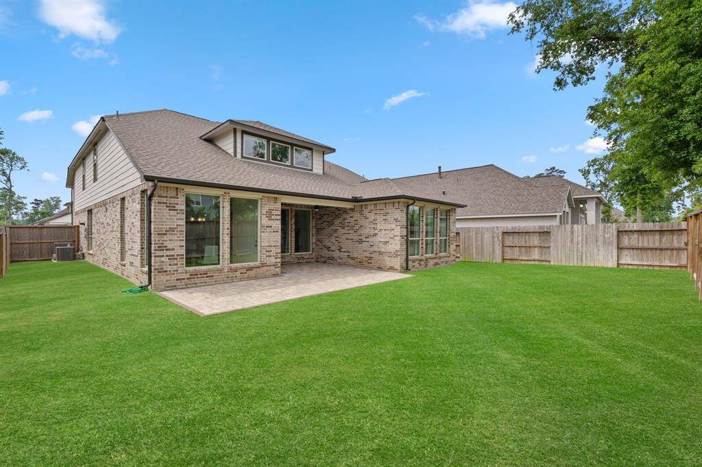 Expansive backyard featuring a newly extended covered patio, perfect for outdoor relaxation and entertaining.