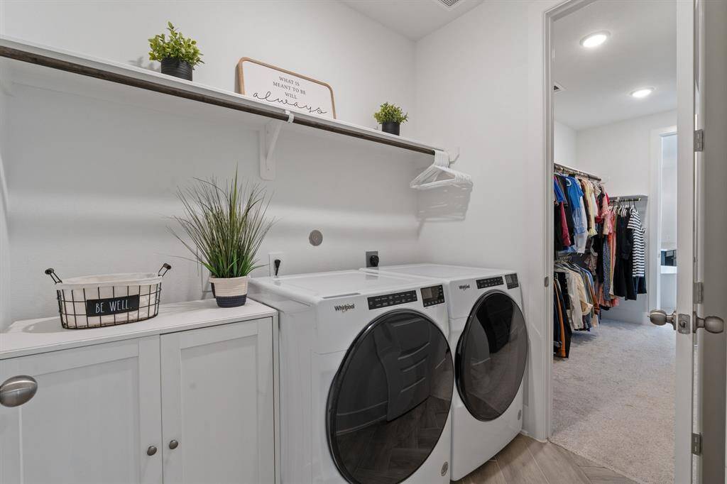 Convenient laundry room with shelving, seamlessly connected to the primary closet and bedroom.