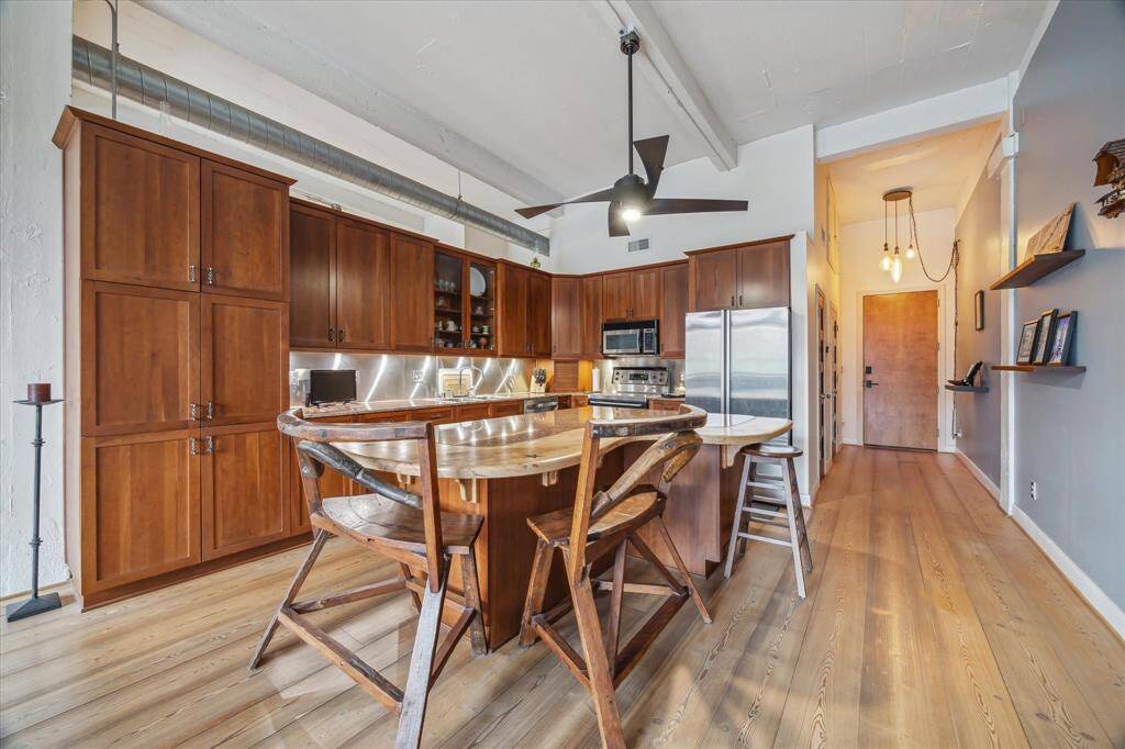 Island includes a wooden bar with seating for casual eating.