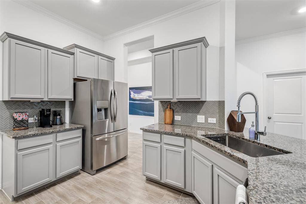 Notice the oversized stainless-steel sink and gorgeous herringbone backsplash.