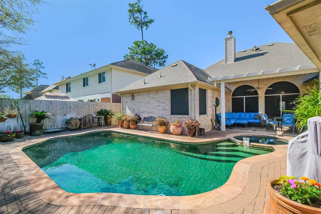 Your backyard oasis features a private pool, surrounded by a brick patio and lush greenery.