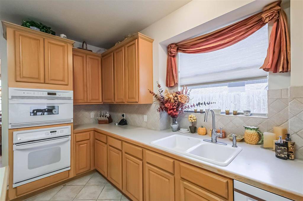 Dual basin sink, plenty of cabinet storage, and a large window with natural light for floral accents, or space for your own herb garden
