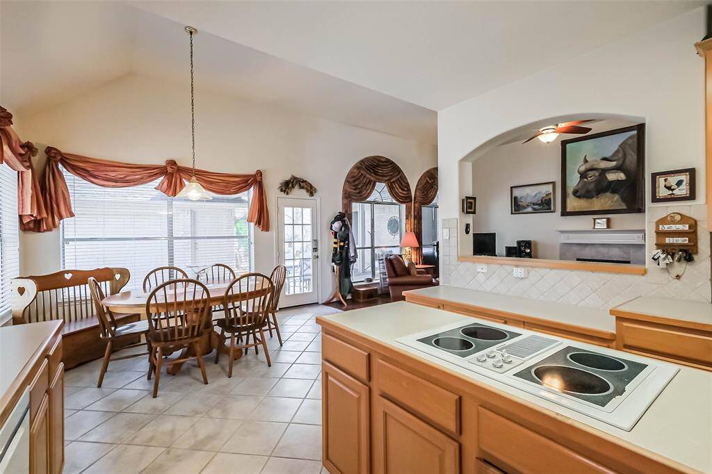 Another view of the island cooktop, this showcases the adjacent breakfast nook.Open floor plan means that you'll never miss a moment while entertaining. Breakfast bar area features an elegant archway adjacent to the living room.