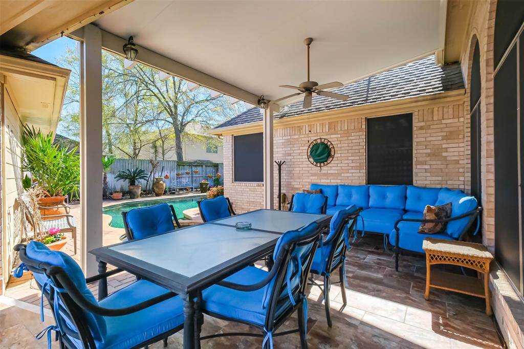 The covered outdoor patio isadjacent to a backyard pool, surrounded by landscaping and a privacy fence—ideal for relaxation and entertaining.
