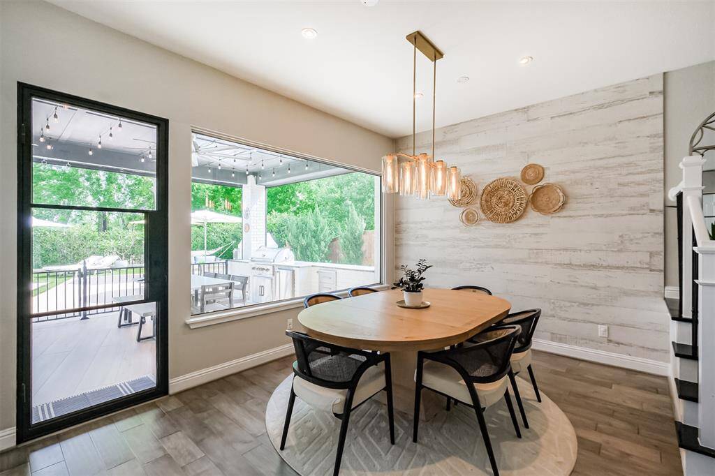 The breakfast room has wonderful, uninterrupted views of the back yard thanks to the upgraded 10ft long one piece window and black metal door that the current owners installed to replace the original builder grade items.