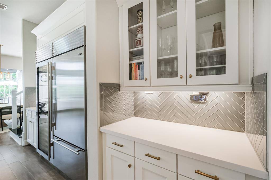 Glass fronted cabinets are in which to showcase your fine china and stemware. Notice the glass tile in a timeless Herringbone pattern.