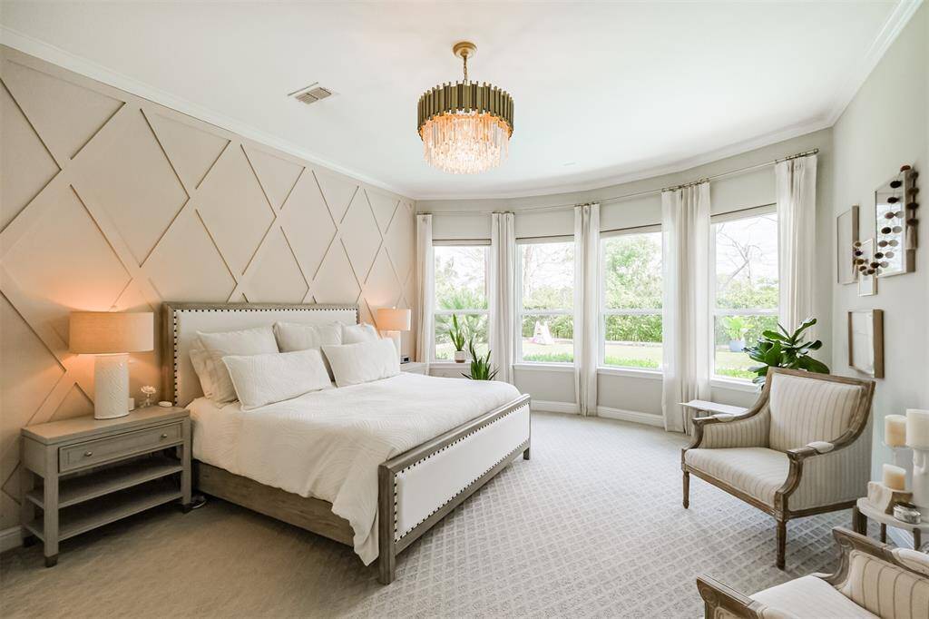 The serene primary retreat has outstanding views through the upgraded, graceful bay windows, a wood-trim feature wall with and enough space for a seating area.