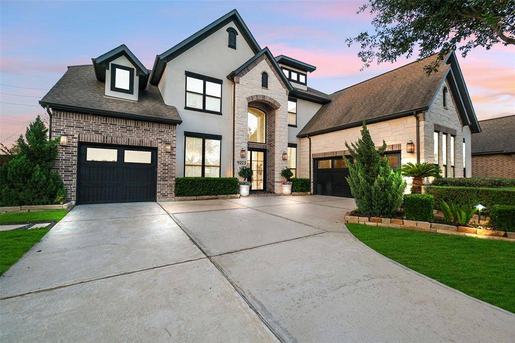 The stunning front elevation features classic brick, limestone and stucco. Hand stacked limestone lines the front garden beds and accentuates the lush landscaping. Over 70 landscaping lights, powered by 2 300watt transformers, surround the home. Tasteful Kichler lantern lighting enhances the curb appeal.