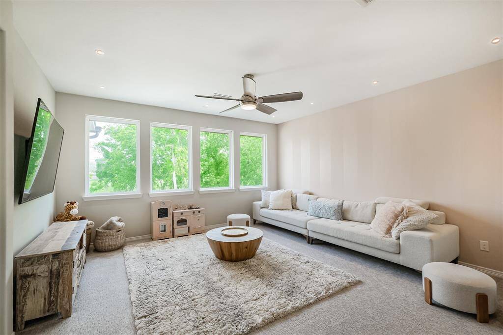 Huge, light and bright game room on the second floor features a hand-painted wall designed to look like large vertical stripes. The windows overlook the backyard oasis and tree-lined reserve behind the house.