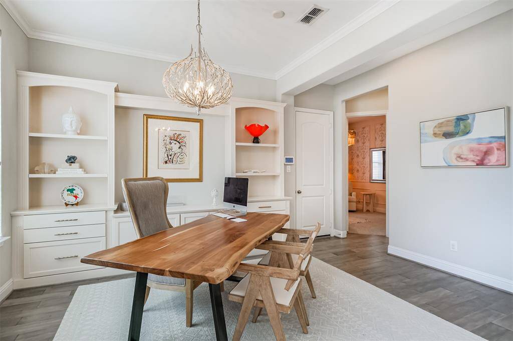 The beautiful study is situated to the left of the foyer as you enter. Shelving and built-in pull drawers and cabinets create a beautiful work-from-home setting.