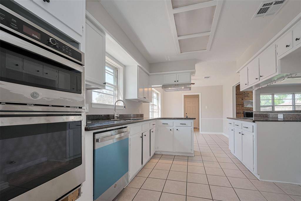 Bright and versatile space with hardwood floors and neutral walls, perfect for a formal dining area or second living room.