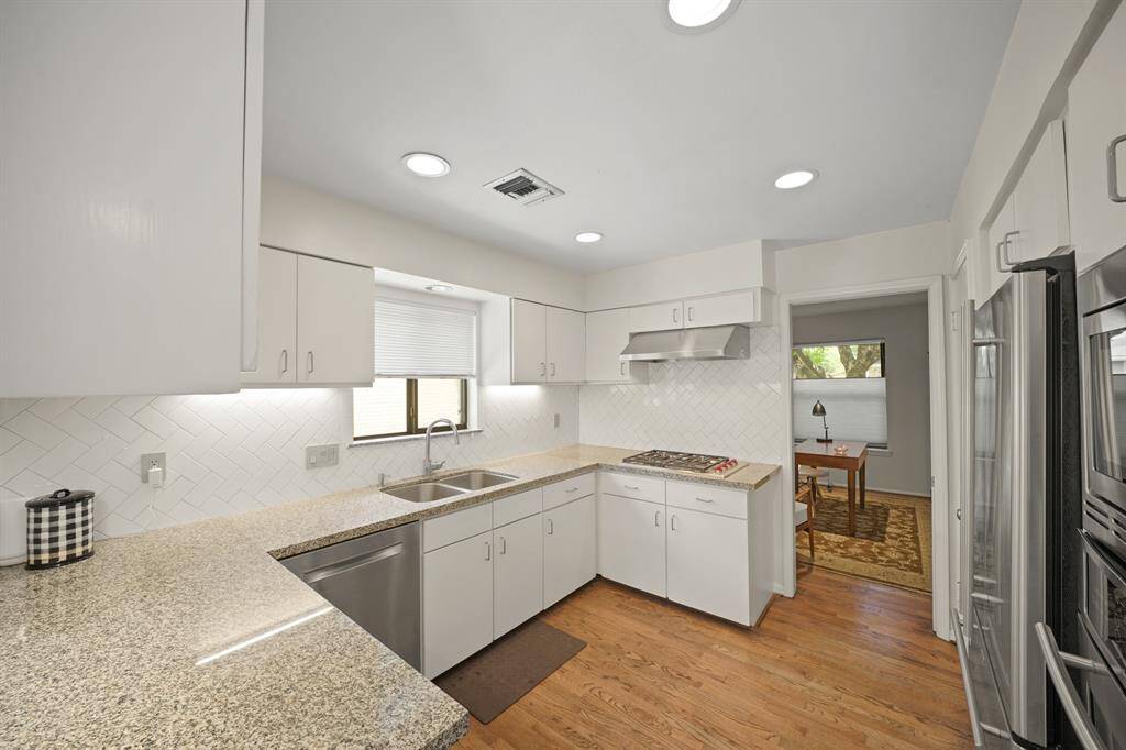 This Beautifully Updated Kitchen also features a Jennaire Stainless Steel Oven, Jennaire Stainless Steel Microwave, Jennaire Stainless Steel French Door Style Refrigerator (Remains per Seller), Recessed Lighting, Red Oak Hardwood Floors (2019*), and a Walk in Pantry (Approximately 8'9" x 4'7") with Built in Shelves and Wall Mounted Wire Shelves (*per Seller).