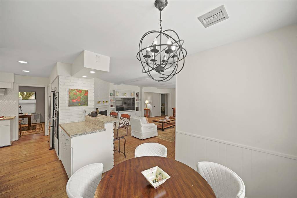 The Kitchen also features an Open Serving Bar/Breakfast Bar from the Kitchen to the Den with Recessed Lights above. The Kitchen is adjacent to the Breakfast Room for Ease in serving Meals.  The Breakfast Room features Red Oak Hardwood Floors (2019 per Seller) and a Treated Metal Orbit Chandelier.