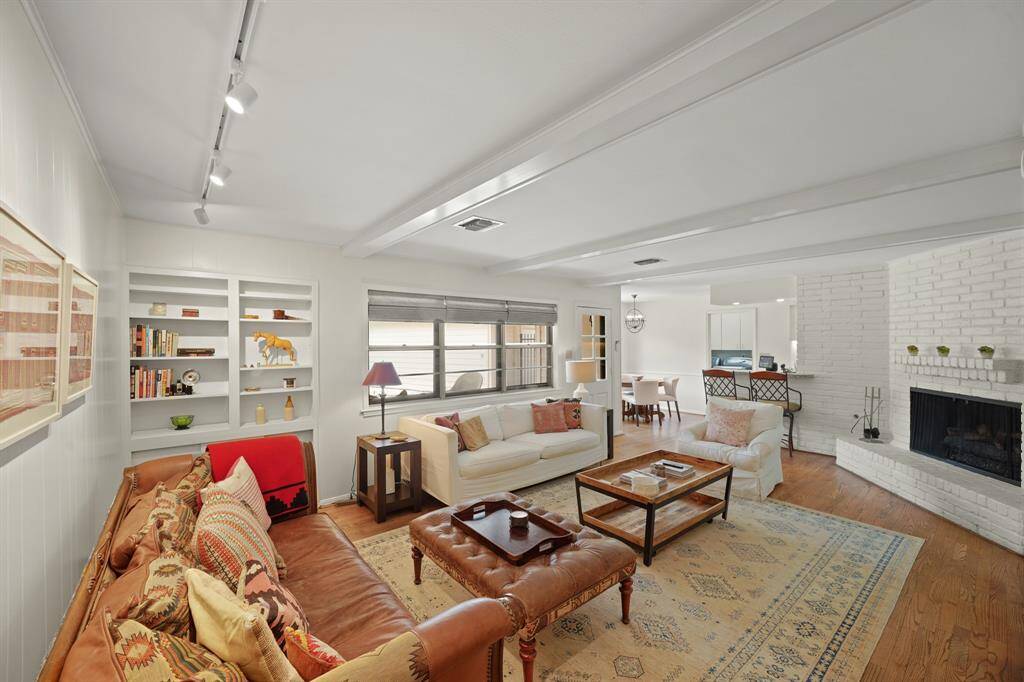 The Open and Bright Living Area offers Triple Windows (with Woven Roman Shades) that view the Outdoor Patio, Sparkling Pool, and the Backyard.  A Door, with Exterior Storm Door, opens to the Outdoor Patio and Yard.