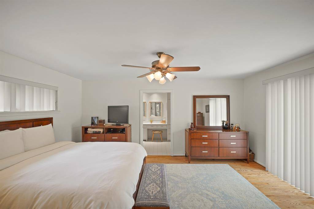 The Primary Bedroom offers a Ceiling Fan with Wood Style Blades and Light (with Opaque Glass Shades).