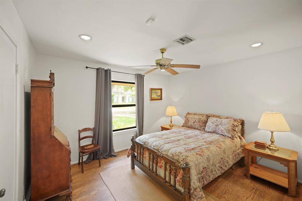 The Third Bedroom features Red Oak Hardwood Floors (2019 per Seller), Picture Sized Window that views the Landscaped Front Yard and the Mature Oak Trees, and Velvet Style Fabric Window Coverings.