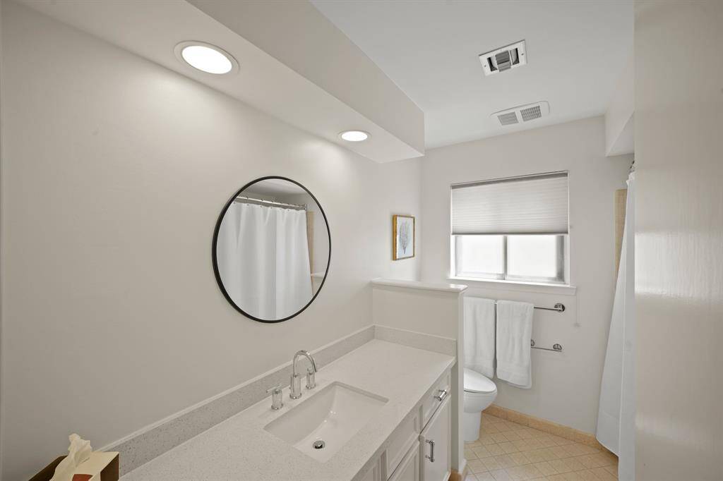 The Hall/Guest Bath offers a Silestone Vanity (2019*), Undermount White Porcelain Sink (2019*), Polished Chrome Faucet and Handles, Ivory Hued Cabinets/Drawers, Round Mirror, Full Tub/Shower with Tile Surround, and a Toto Commode (*per Seller). Additional Features include a Two Tiered Side by Side Linen Cabinet/Storage Cabinet, Recessed Lighting, Polished Chrome Hardware, Polished Chrome Towel Rack and Paper Holder, Slider Window, and Tile Floors.