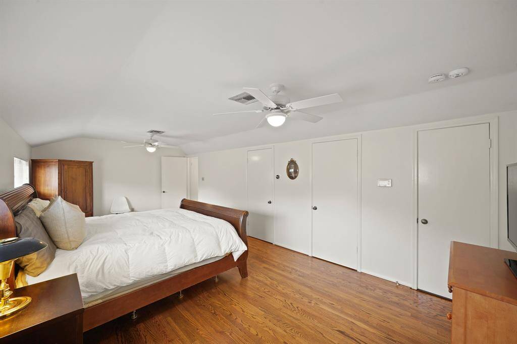 The Fourth Bedroom features Red Oak Hardwood Floors (2019 per Seller), Dual Ceiling Fans with Globe Style Lights, Wardrobe Closet with Built in Shelves, Additional Wardrobe Closet with Hanging Rod, and an Extra Large Walk in Storage Closet (Approximately 12'6" x 7'8").