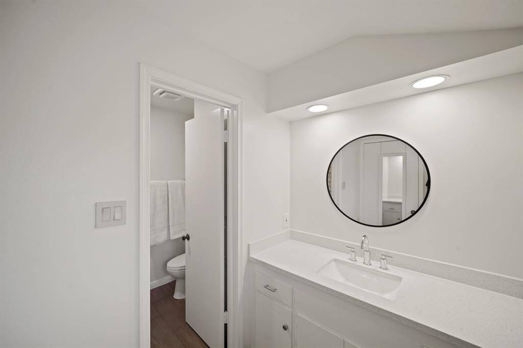 The EnSuite Bath to the Fourth Bedroom features Silestone Countertops (2019*), Undermount White Porcelain Sink (2019*), Polished Chrome Faucet (2019*), White Painted Cabinets/Drawers, Round Mirror, Staggered Grey Tile Floors (2019*), and a Full Tub with Polished Chrome Plumbing Fixtures and Grey Subway Tile Surround (2019*)  (*per Seller).