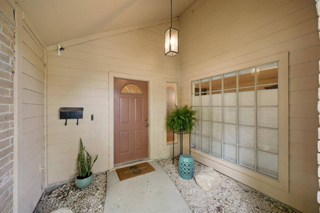 The Front Private Courtyard Area (Approximately 10'1" x 9'3") greets your Guests and features a Wrought Iron Entry Gate, Treated Metal Lantern Style Light Fixture, Garden Area for Plants/Greenery, and a Decorative Brick Wall with Custom Style Openings. A Solid Wood Front Door with Decorative Glass Inset opens to the Foyer. A Decorative Glass Sidelight is adjacent to the Front Door.