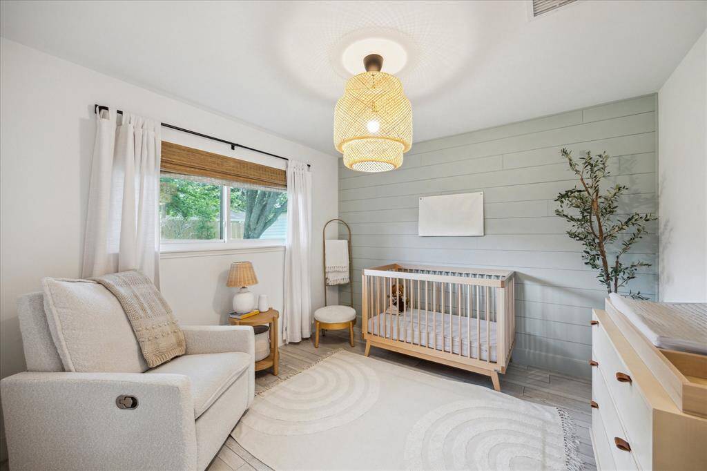 Adorable secondary bedroom features stylish accent wall and modern lighting.