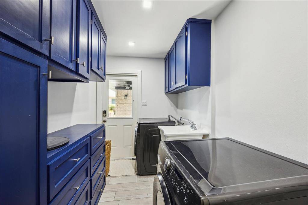 Laundry room features plenty of cabinets great for storage, separate sink and door that opens to the backyard patio!