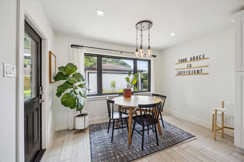 Breakfast area with modern lighting, large windows and back door that opens the the covered patio.