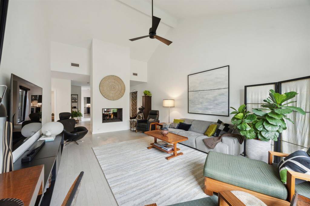 Living Room features modern sloped ceiling, Canadian Red Oak Floors and 2-sided fireplace with ceramic firestones.