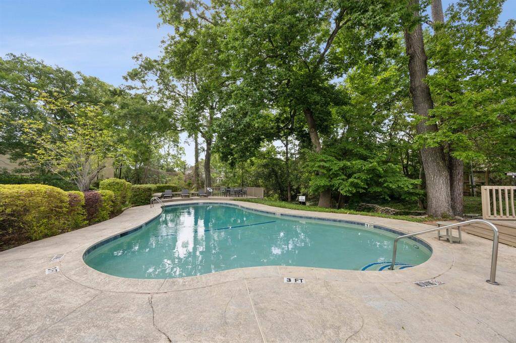 Community pool is surrounded by mature trees.