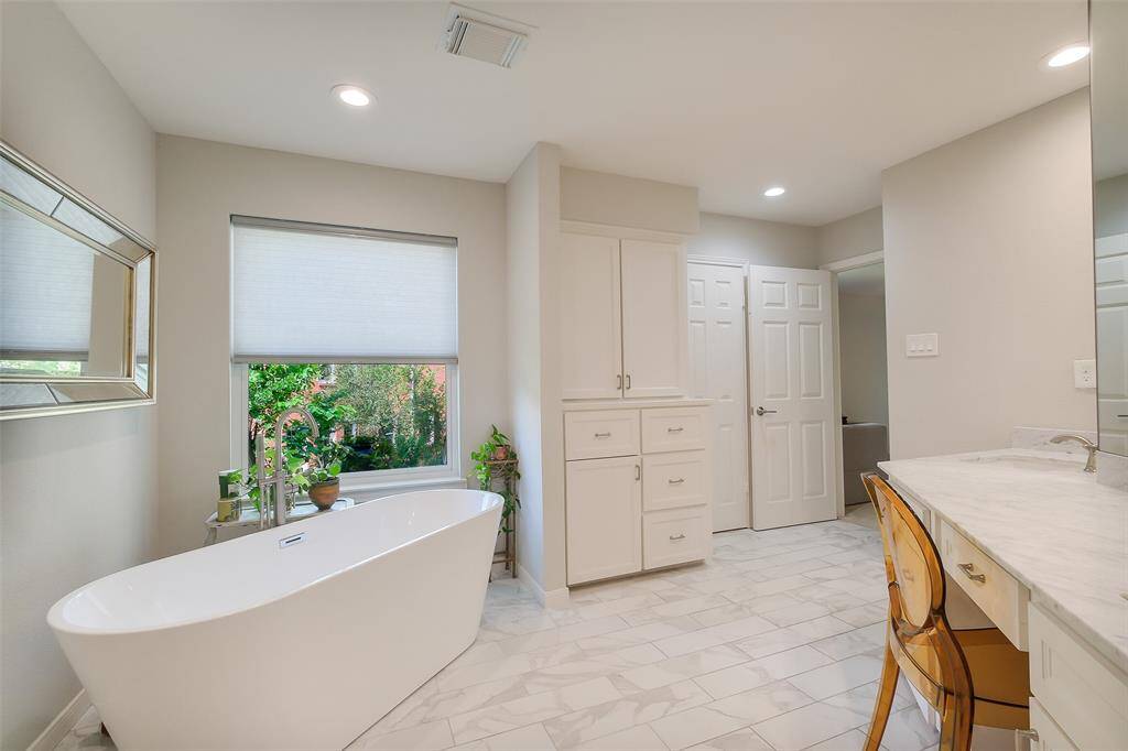 A beautiful soaking tub with sleek floor-mounted filler and a lovely view.
