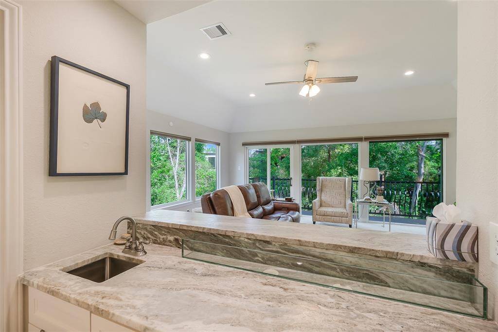 Stylish wet bar overlooking the room with serene views into the trees.