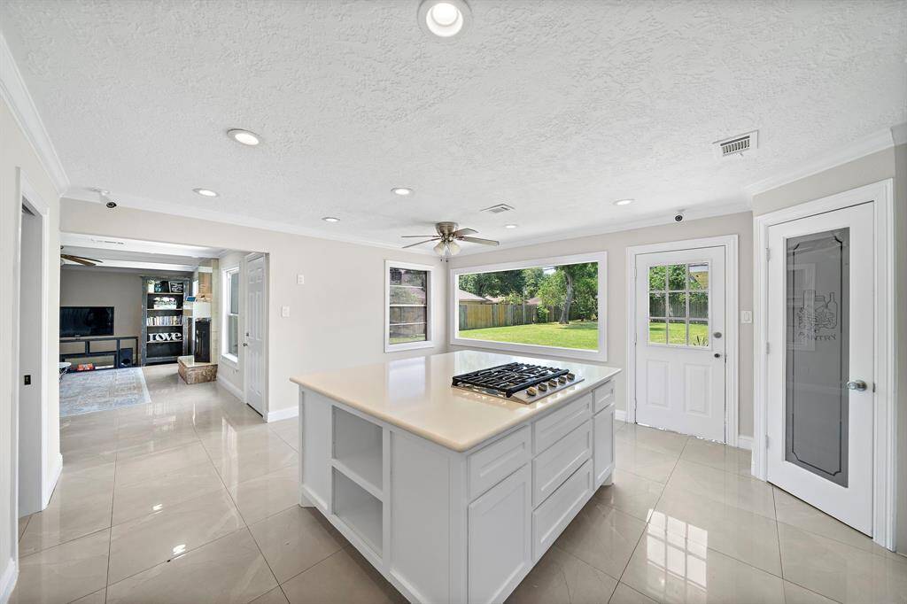 Kitchen featuring an island with cooktop