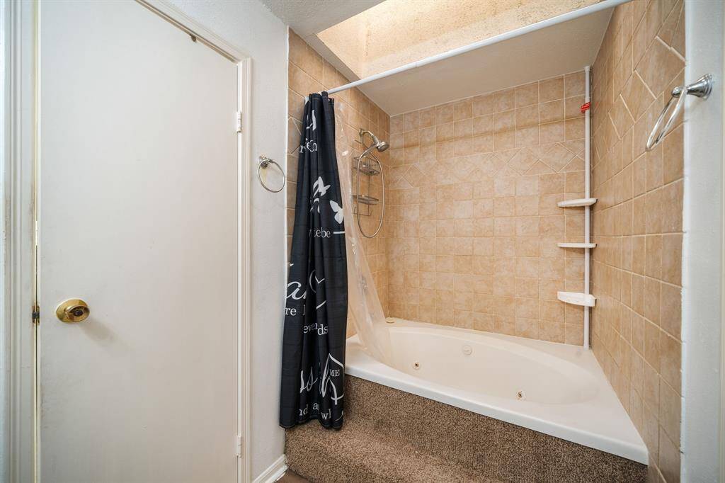 Soak your cares away in this jetted tub, part of the primary bath, complete with a tile surround and an overhead skylight for a bright, spa-like retreat.