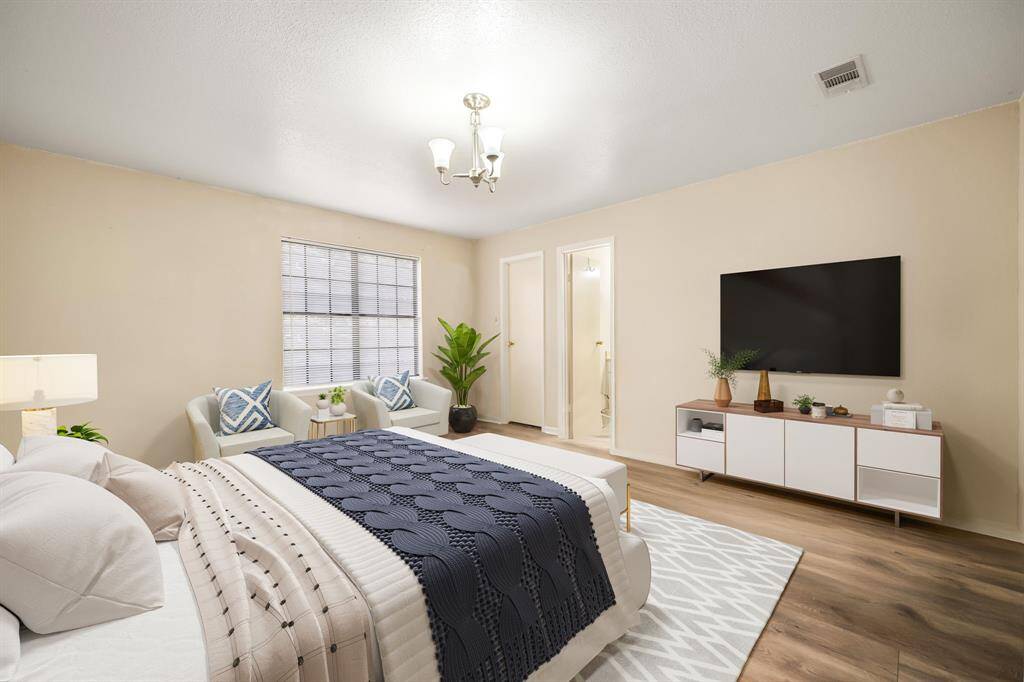 Secondary bedroom features beautiful wood style flooring, custom paint, beautiful custom light, and a large window with privacy blinds. *Virtually Staged