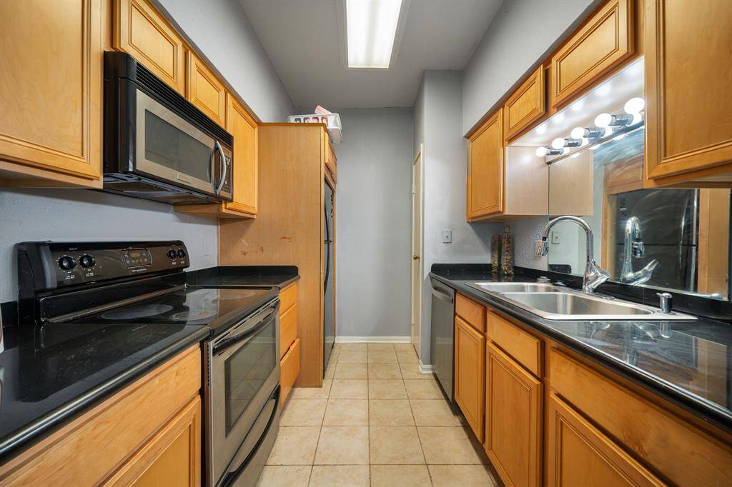 Enjoy preparing meals in this sleek, functional kitchen, complete with stainless steel appliances, ample cabinetry, and striking granite countertops.