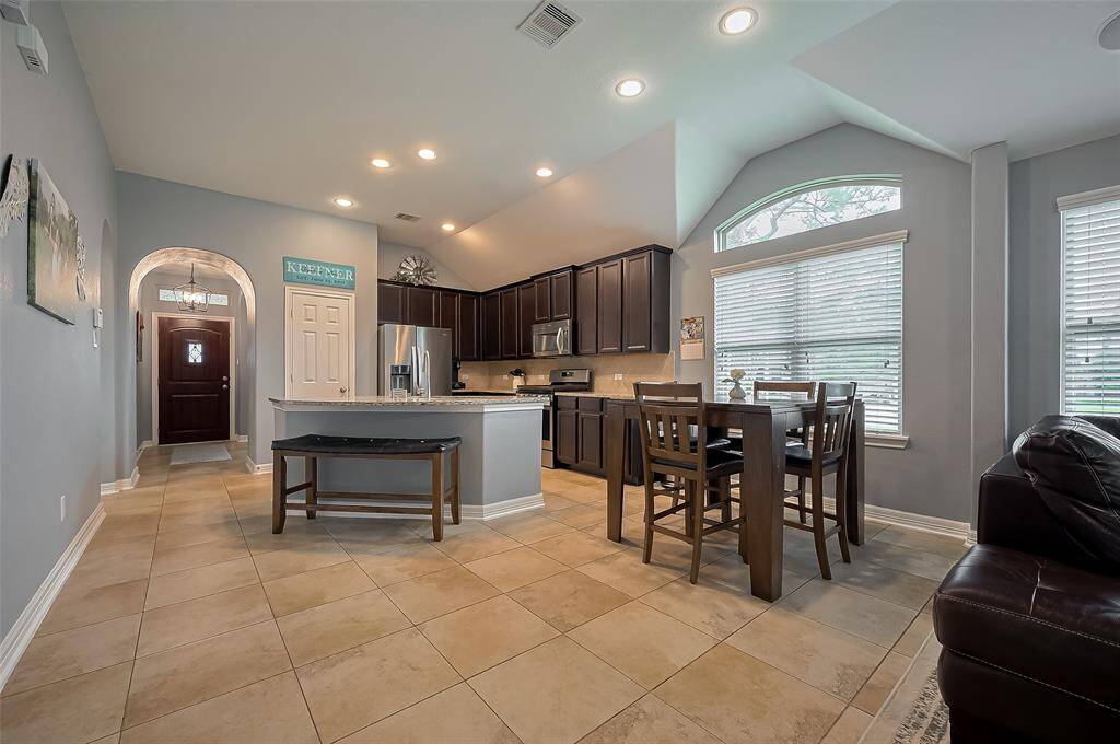 Modern kitchen with stainless steel appliances, granite countertops and open to breakfast area.